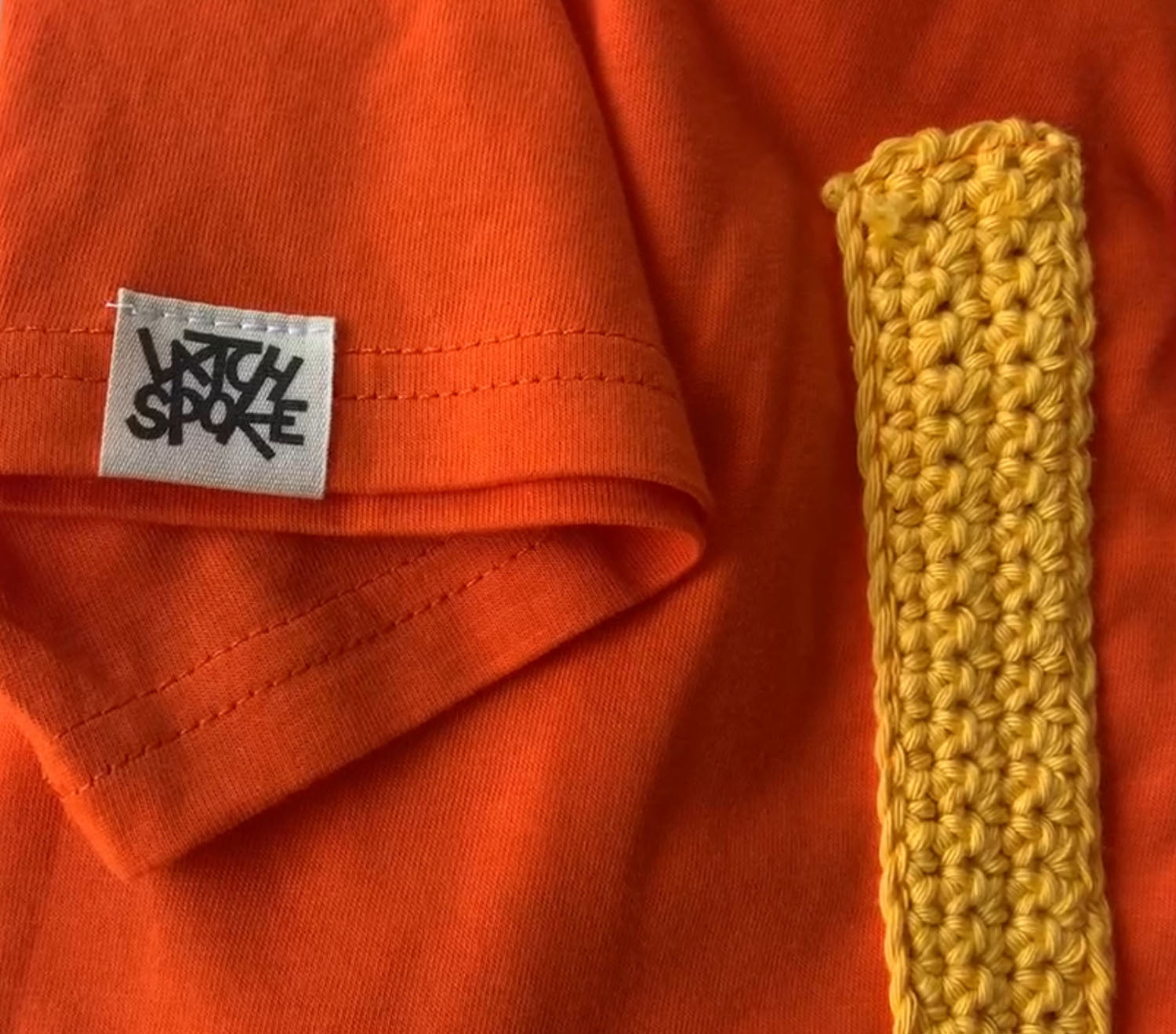 orange t-shirt with a latchspoke label on the sleeve